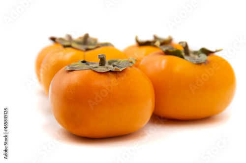 Ripe persimmon on a white background. Seasonal fruit of late autumn.
