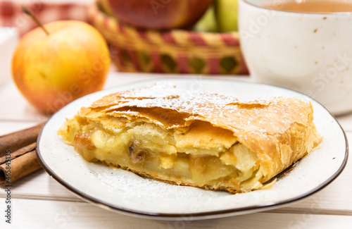 Strudel with apples on a plate. A wonderful dessert made of puff pastry.