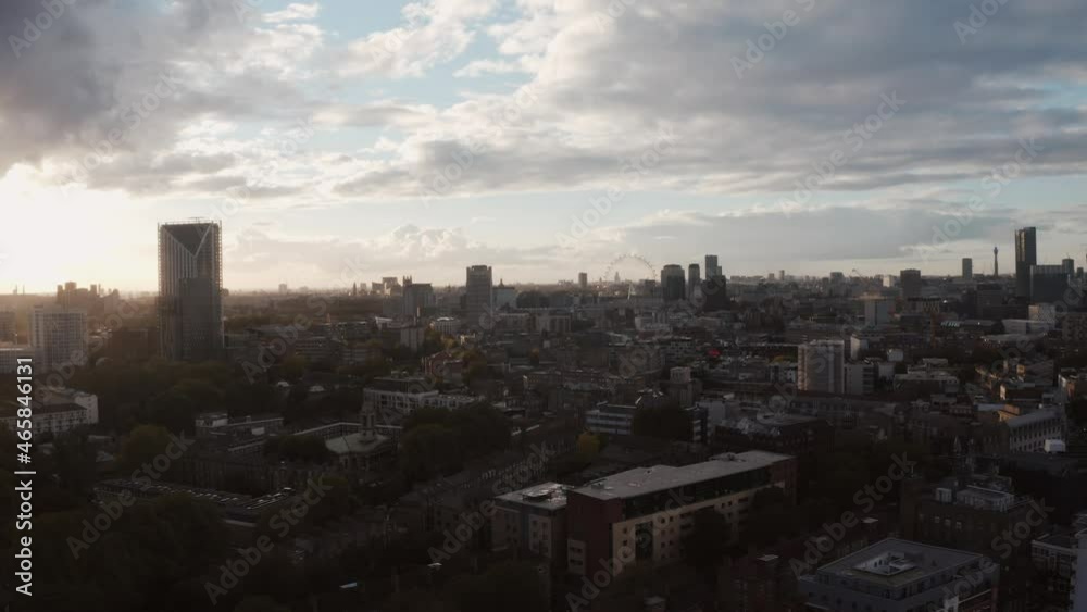 Flying over London city skyline near Shard skyscraper and Canary Wharf in the background. Beautiful sunset view of London. Flying over London city skyline near Shard skyscraper and Canary Wharf in the background. Beautiful sunset view of London.