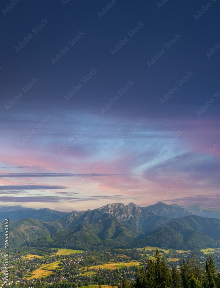 Vertical view of mountains in nature of sleeping knight tatra mountain covered with dramatic clouds aka as giewont and dramatic sunset or sunrise located in Zakopane, South Poland, Europe.