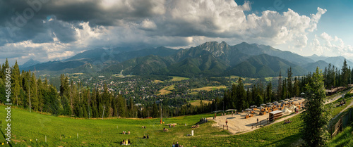 Panoramic view of tourist sitting in nature against sleeping knight tatra mountain covered with dramatic clouds aka as giewont and dramatic clouds located in Zakopane, South Poland, Europe.