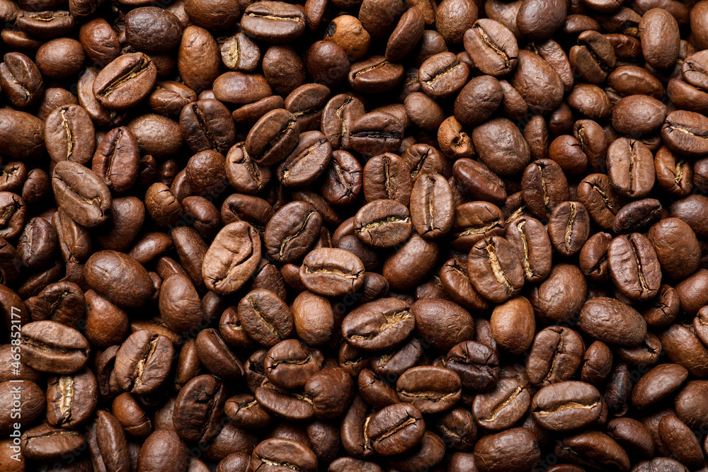 Fototapeta premium Pile of roasted coffee beans as background, top view