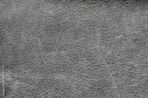 Texture of rough crumpled genuine leather close-up, gray black color, wrinkles, matte surface, trendy background