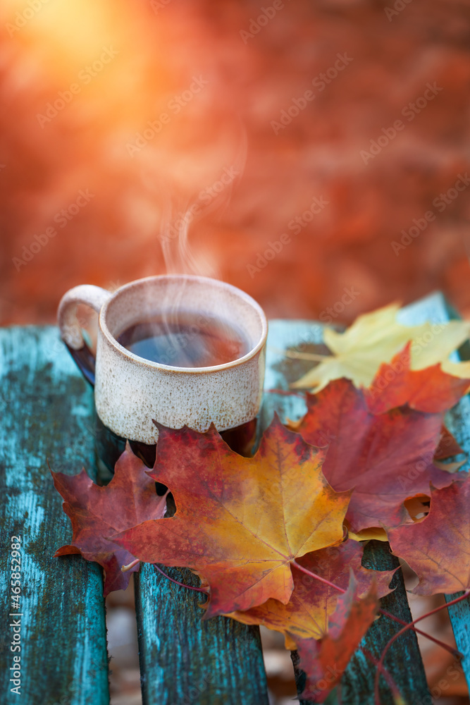 filiżanka kawy w jesienny poranek, kawa o poranku i kolorowe jesienne liście, herbata na tarasie - obrazy, fototapety, plakaty 