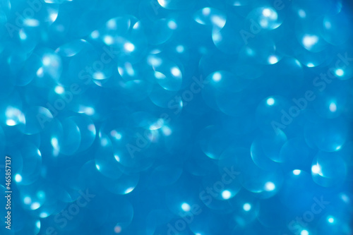 Defocused christmas or party, blue glitter background with bokeh. Holiday glowing backdrop,banner or card.