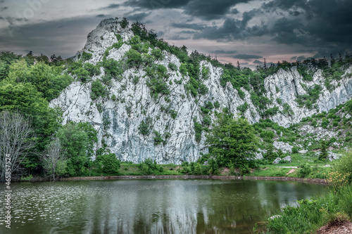 Close up of climbing rock Filipov kuk and lake with dramatic sunset. Velebit Nature Park, Croatia.