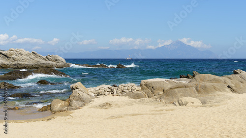 Sea shore sandy beach and waves. View to the rock and clouds. High quality photo