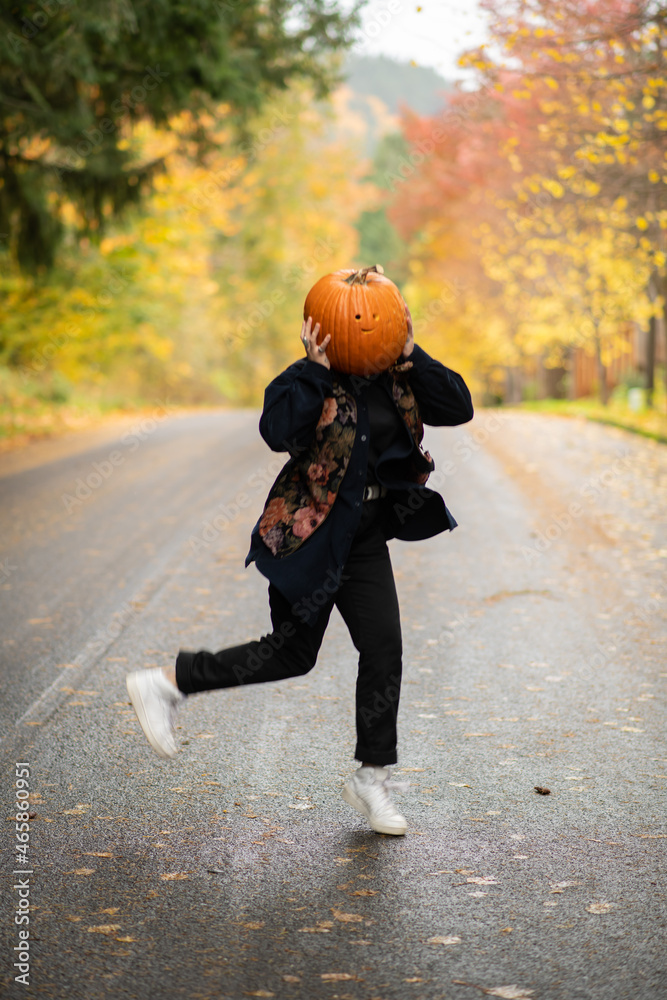 Fototapeta premium person with a pumpkin on their head dancing 