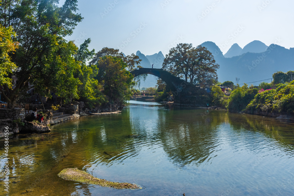 Fototapeta premium YANGSHUO, CHINA, 6 DECEMBER 2019: Fuli bridge on the Yulong River in the countryside of Yangshuo