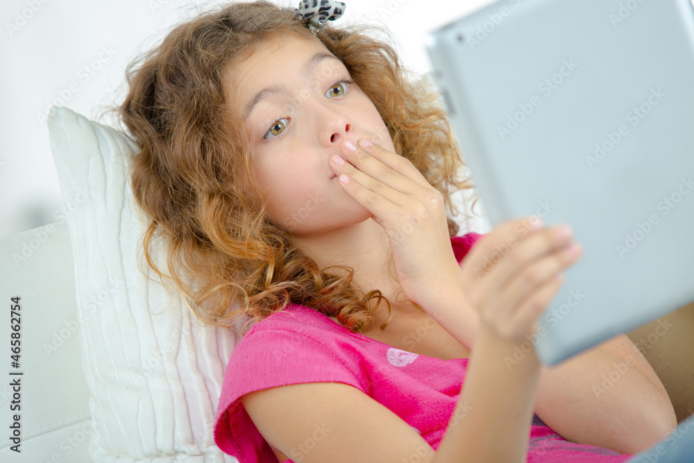 School girl holding tablet, worried expression School girl holding tablet, worried expression