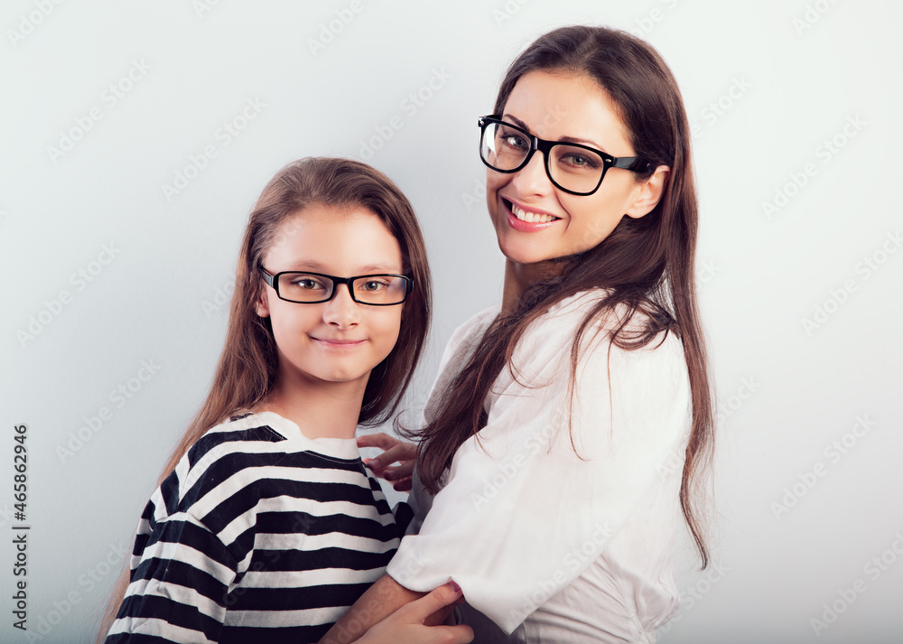 Happy young mother and lauging kid in fashion glasses hugging on empty copy space background. Family Happy young mother and lauging kid in fashion glasses hugging on empty copy space background. Family