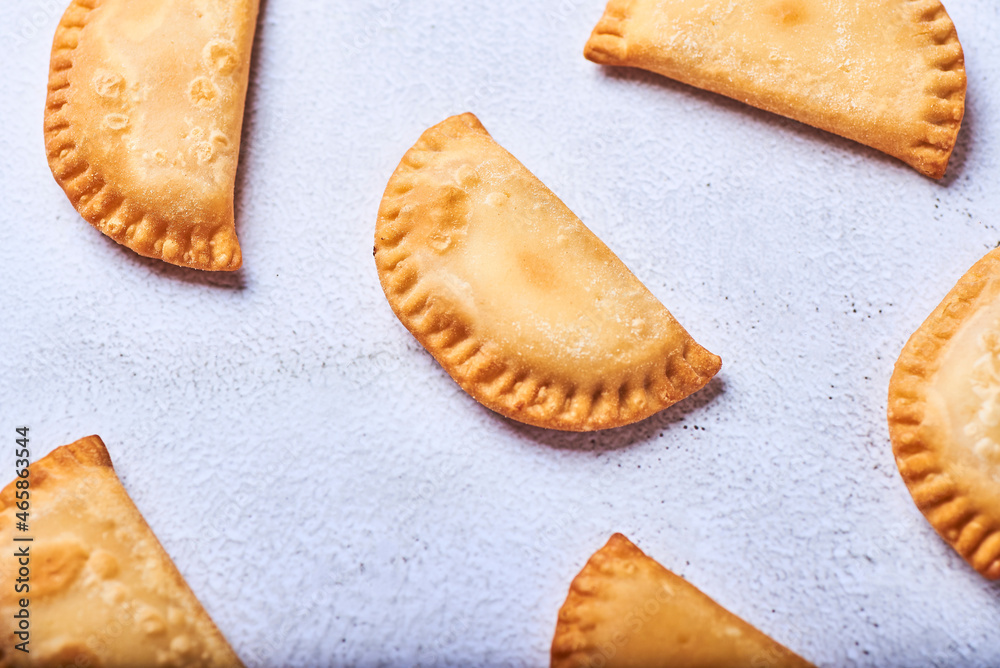 Empanadillas rellenas de atun con tomate y cebolla sobre un fondo blanco. Empanadillas rellenas de atun con tomate y cebolla sobre un fondo blanco.