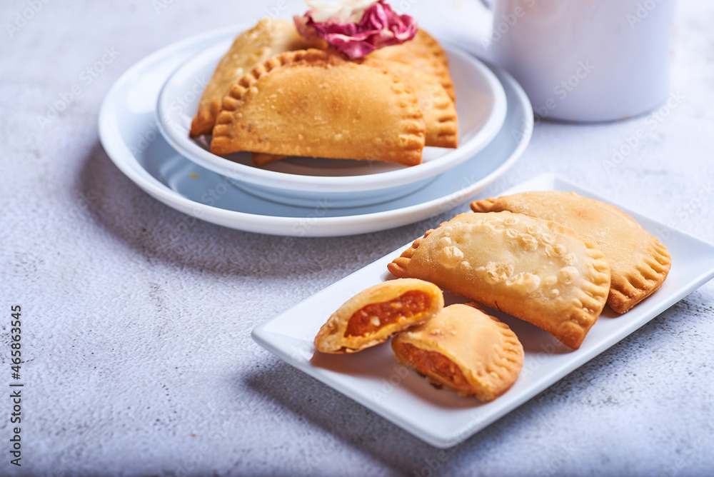 Empanadillas rellenas de atun con tomate y cebolla sobre un fondo blanco. Empanadillas rellenas de atun con tomate y cebolla sobre un fondo blanco.