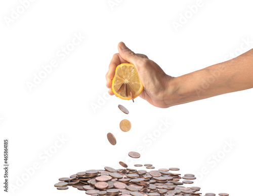 Human hand squeezing a lemon from which coins come out