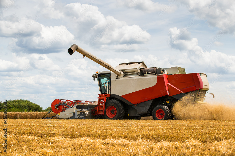 Combine harvester in action on wheat field. Harvesting is the process of gathering a ripe crop from the fields. Combine harvester in action on wheat field. Harvesting is the process of gathering a ripe crop from the fields.