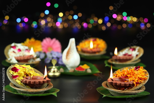 Diya Or Deep Lit In Leaf bowls On Called Patravali or Pattal Dona Katori Decorated With Paan Shankh Roli Haldi And Flowers. Theme For Diwali, Navratri Pooja, Dussehra Puja And Shubh Deepawali photo