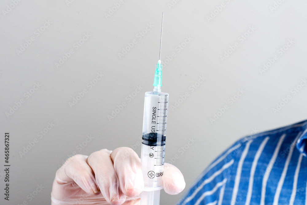 hand in glove holds a syringe. Doctor holds a syringe for vaccination. hand in glove holds a syringe. Doctor holds a syringe for vaccination.