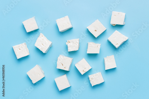 A diced pieces of tofu on blue background top view.