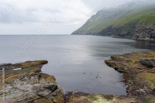 Beautiful aerial view of Faroe Islands Towns next to the ocean Canals, and boats and massive mountains. photo