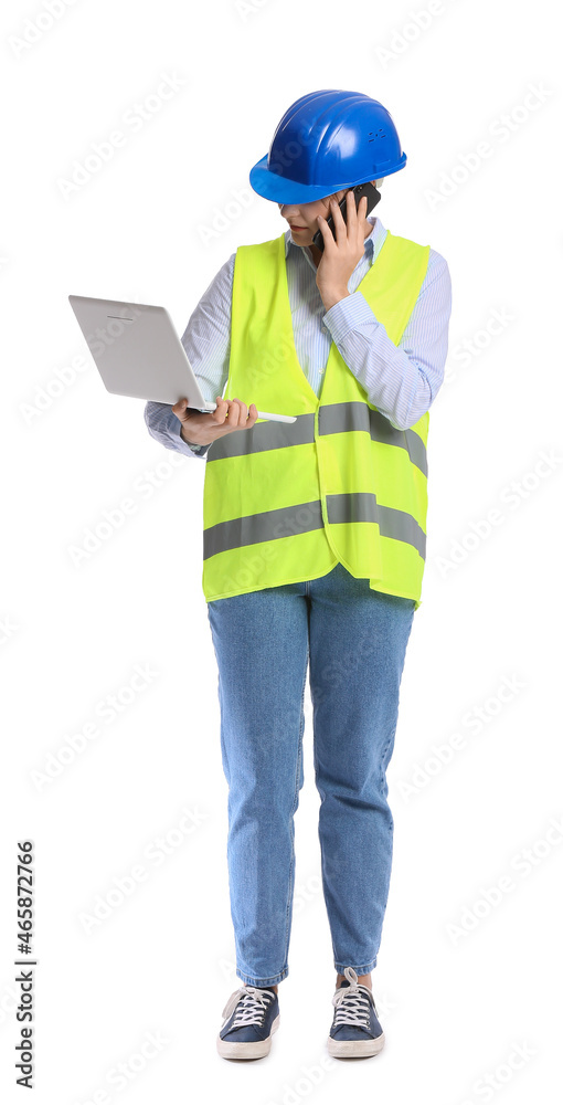 Female construction worker with laptop talking by mobile phone on white background Female construction worker with laptop talking by mobile phone on white background