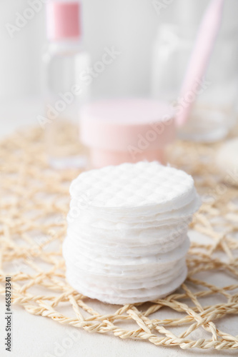 Wicker mat with cotton pads on table, closeup