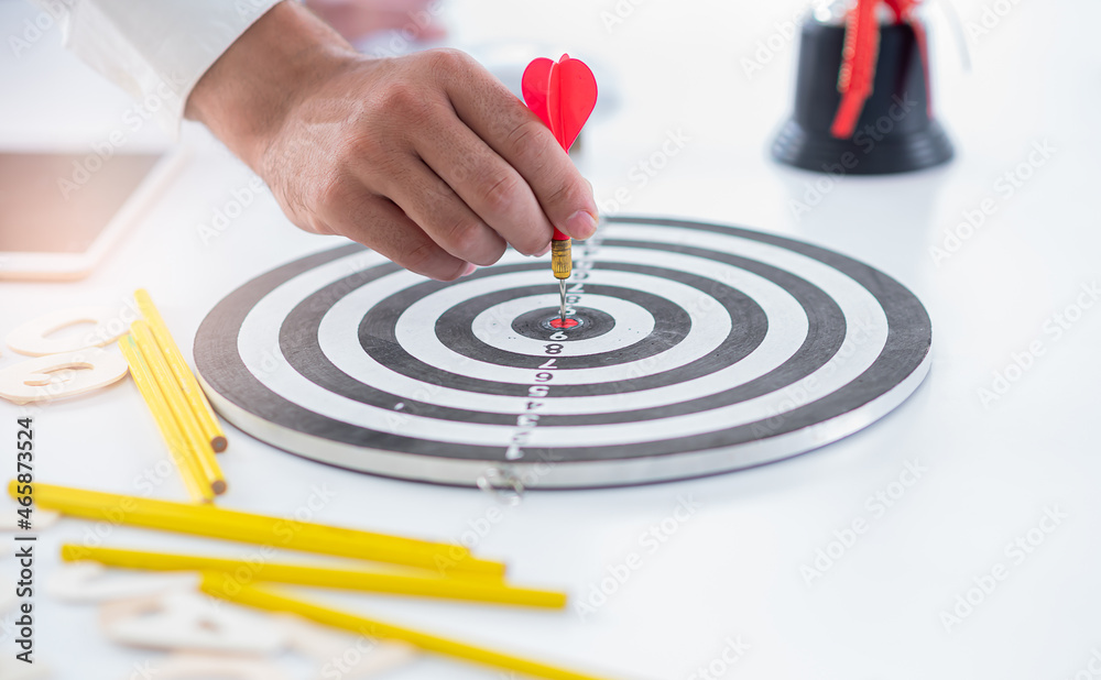 business man push dart to dartboard,concept business targeting and and marketing goal business man push dart to dartboard,concept business targeting and and marketing goal