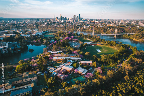 Aerial shot of Brisbane in jacaranda season with the University of Queensland in the foreground 