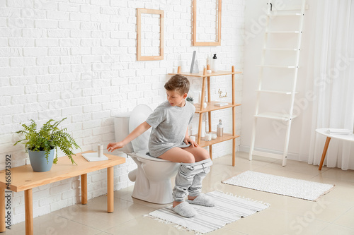 Little boy out of toilet paper in bathroom photo