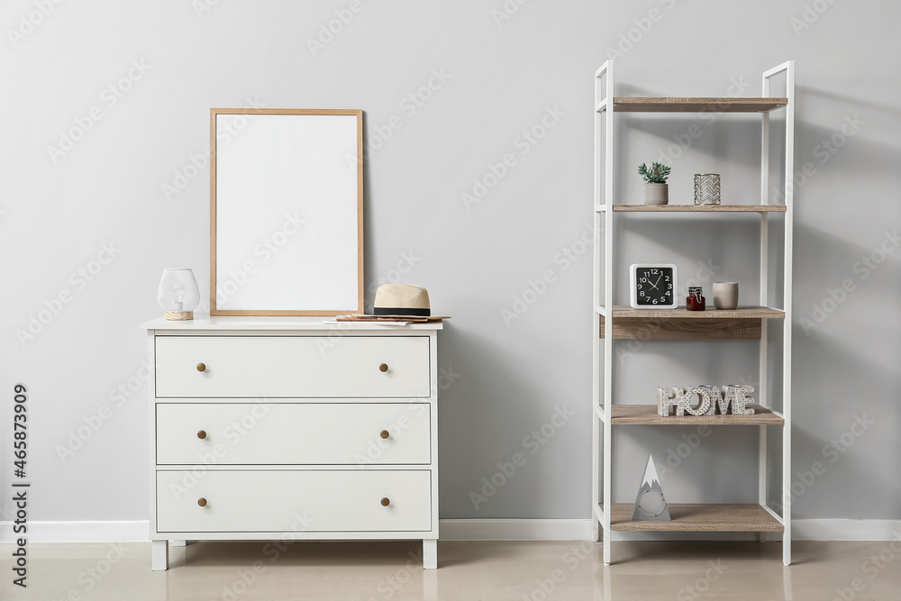 Blank poster frame on chest of drawers near light wall Blank poster frame on chest of drawers near light wall