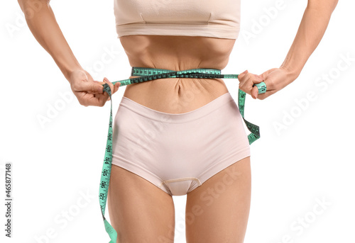 Young woman with measuring tape on white background. Anorexia concept