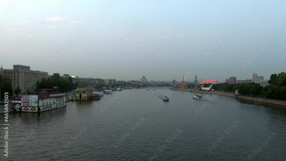 Moscow, Russia - 16 August 2010: Boats are floating along the river in evening. Beautiful views of capital at sunset. Arched steel construction in big city. Moscow, Russia - 16 August 2010: Boats are floating along the river in evening. Beautiful views of capital at sunset. Arched steel construction in big city.