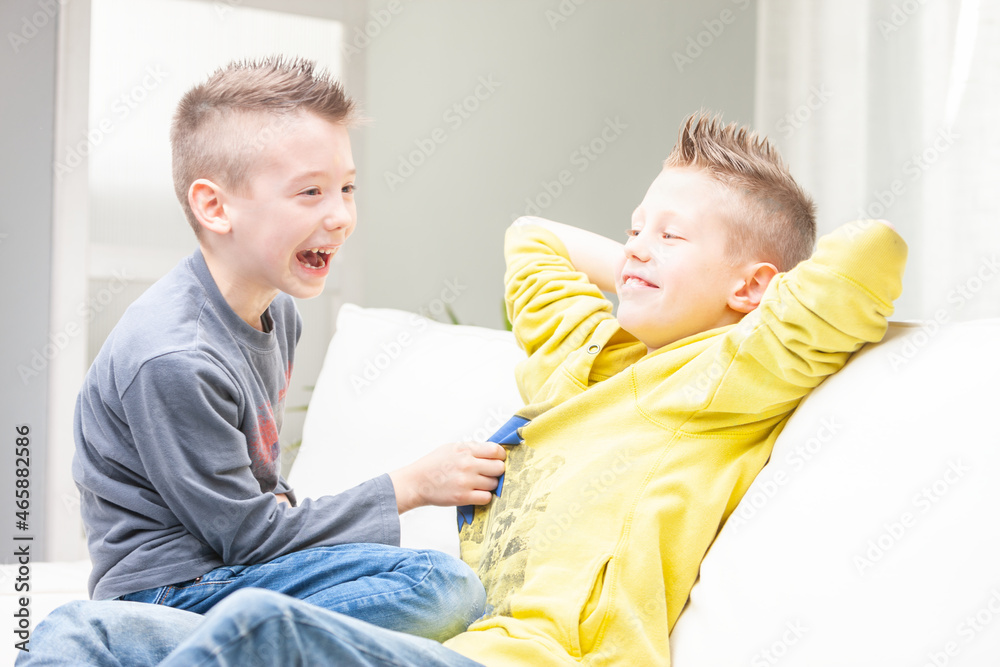 Fototapeta premium Cute funny young boy laughing at his brother
