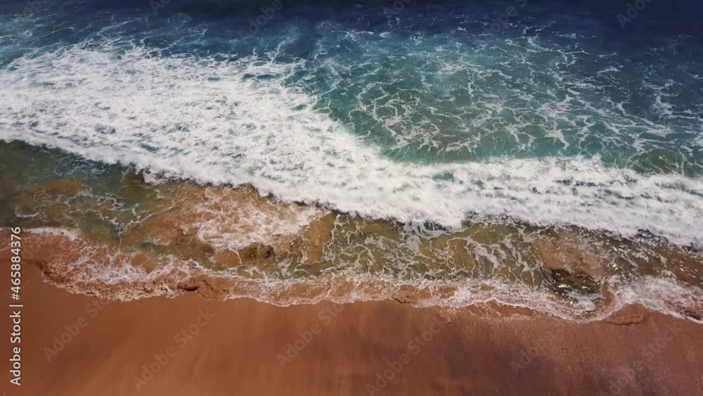 Drone aerial view of waves breaking on golden sand beach Drone aerial view of waves breaking on golden sand beach