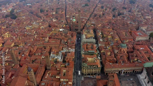 Bologna, Emilia-Romagna, Italy, October 2021. Drone pushes east over Via Francesco Rizzoli towards the Two Towers surrounded by the Medieval city center on an overcast hazy day. photo