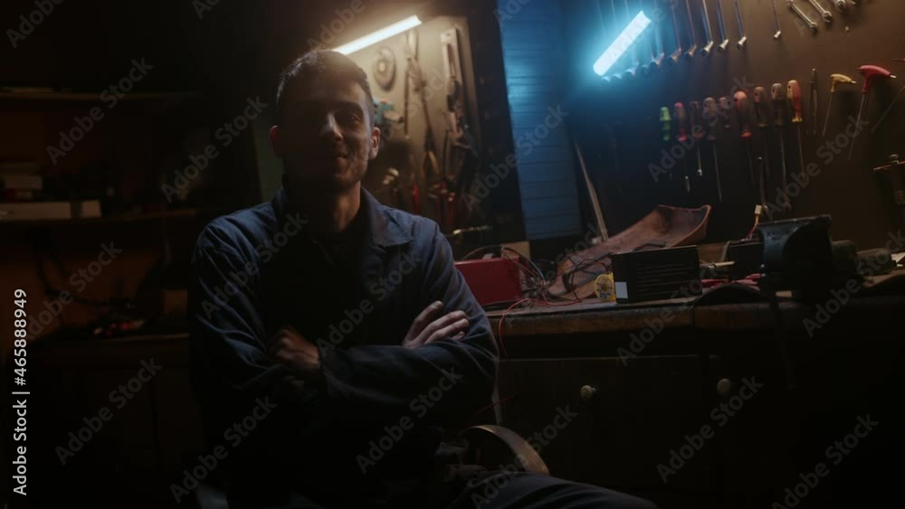 Small workshop owner young happy man sitting on chair, fold one's arms and looking at camera and smiling. Small workshop owner young happy man sitting on chair, fold one's arms and looking at camera and smiling.