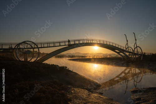 Bicycle-shaped bridge with water fog rising from the beach