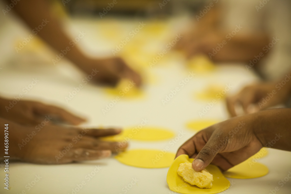 Human Hands making Raw and dry capeletti pasta on kitchen table Human Hands making Raw and dry capeletti pasta on kitchen table