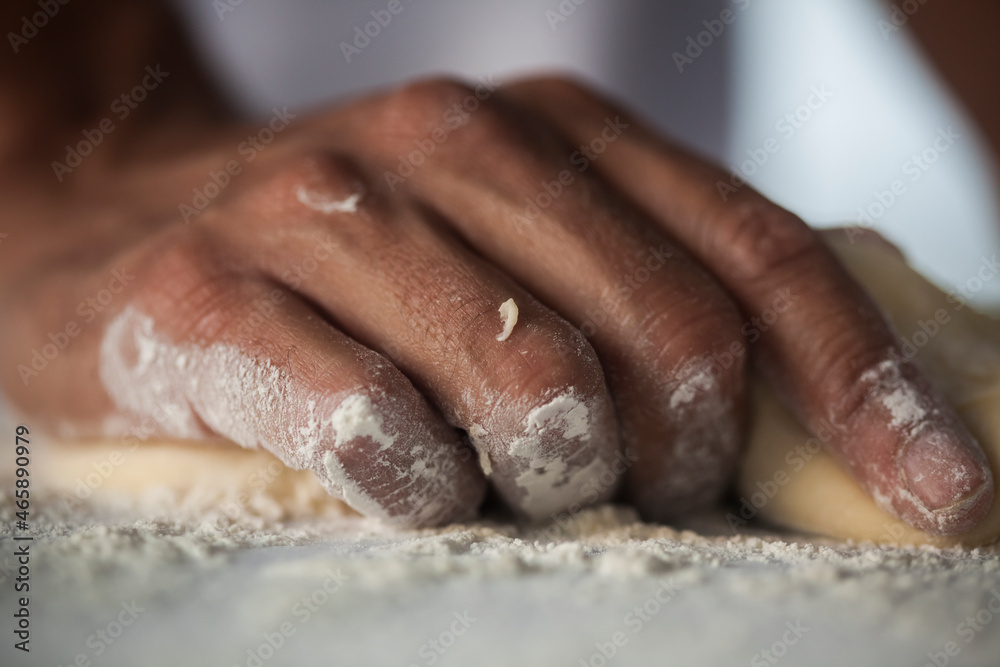 Human Hand making pasta - making Raw and dry pasta on kitchen table - flower Human Hand making pasta - making Raw and dry pasta on kitchen table - flower