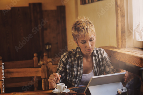 young woman in a country resteurant working at laptop photo