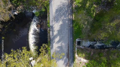 Top view of the bridge on Vine Brook Pond and water flowing through Wilson Mill dam in spring in town of Bedford, Massachusetts MA, USA.  photo