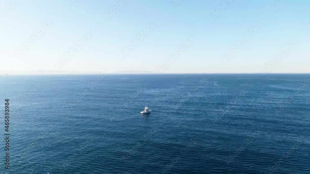 Far away aerial half circle shot of a boat in the ocean. Far away aerial half circle shot of a boat in the ocean.