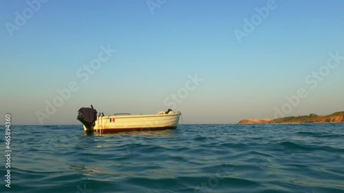Motorboat with no one on board fluctuates and swings in middle of sea. Low-angle pov photo