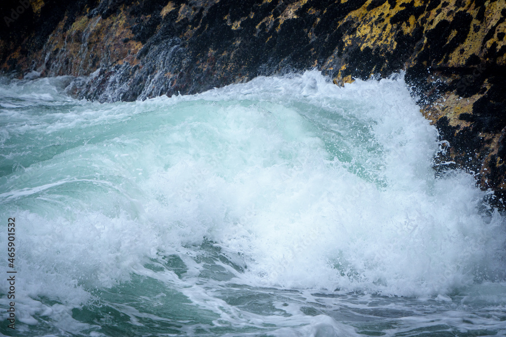 Beautiful ocean waves breaking onto mussel covered rocks. Hermanus. Whale Coast. Overberg. Western Cape. South Africa.