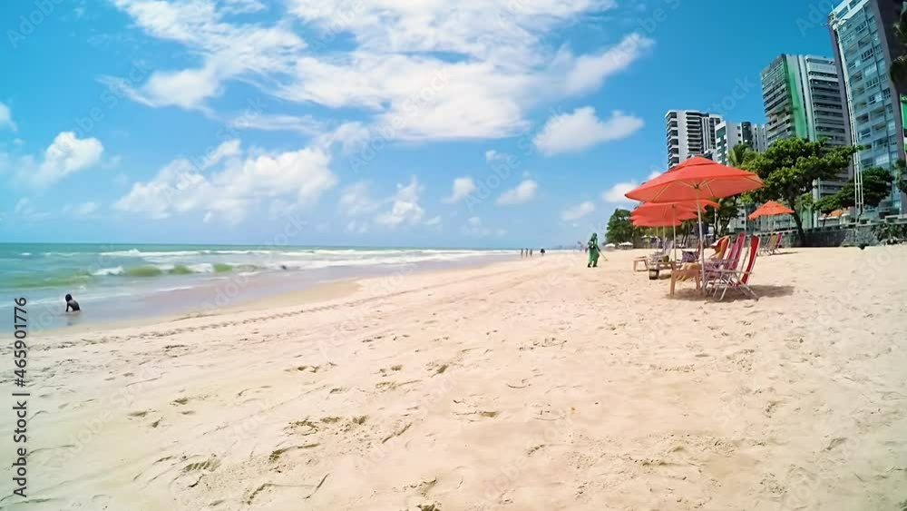 Time-lapse video of the morning at the beach of Boa Viagem. Bathers and vendors on the beach. People enjoying the day at the beach on a beautiful sunny day.