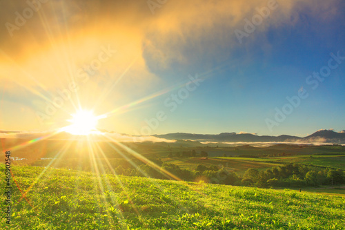 大雪山から昇る朝日の光芒と牧草地の草原, 美瑛町,上川郡,北海道