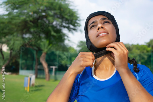 Young girl properly wearing her helmet alone on the field