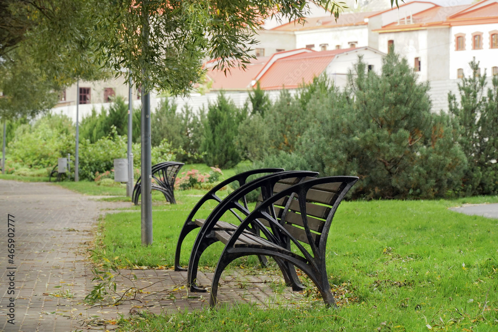 modern bench in the park against the background of houses