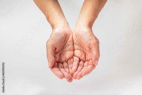 Mãos vazias estendidas em forma de concha, como se pedisse ou estivesse prestes a receber algo, sobre fundo branco photo