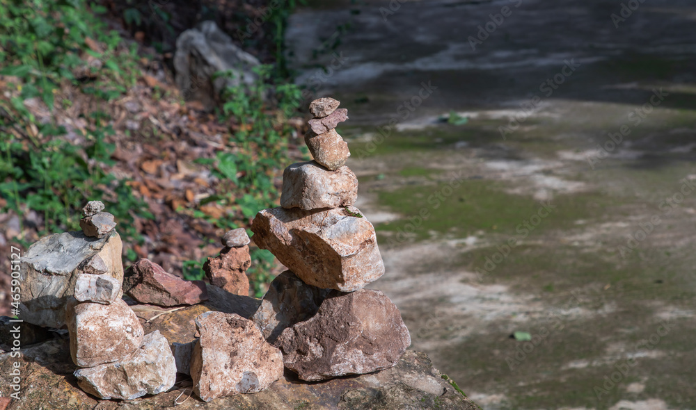 Balanced stone tower on walkway up the mountain with green plants in the background. No focus, specifically. Balanced stone tower on walkway up the mountain with green plants in the background. No focus, specifically.