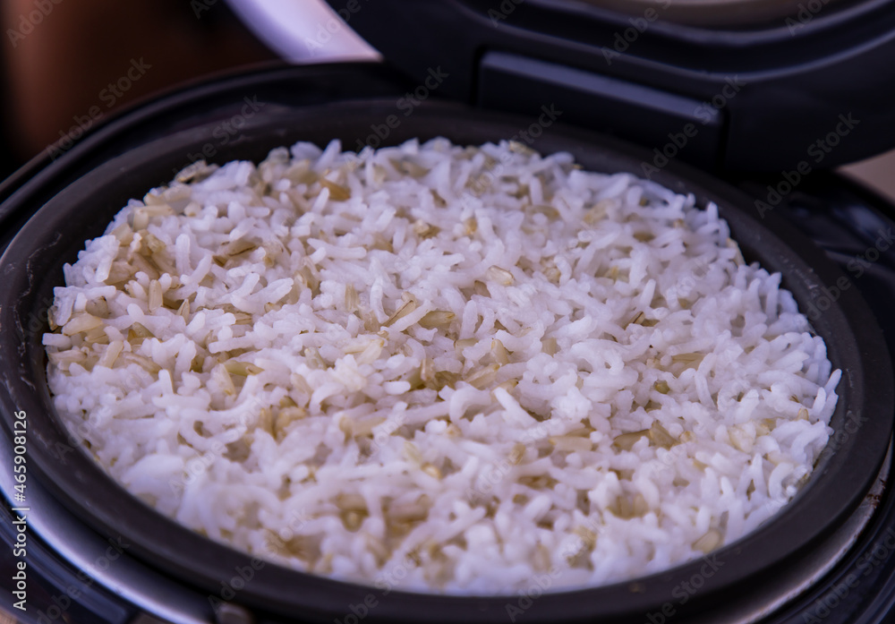 Jasmine rice Cooking mixed with Coarse brown rice (milled rice imperfectly cleaned, unpolished or half milled rice) in electric rice cooker with steam. Healthy food and diet concept. Selective focus. Jasmine rice Cooking mixed with Coarse brown rice (milled rice imperfectly cleaned, unpolished or half milled rice) in electric rice cooker with steam. Healthy food and diet concept. Selective focus.